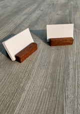 Two small wooden business card holders with blank white cards, placed on a gray wood-textured surface.